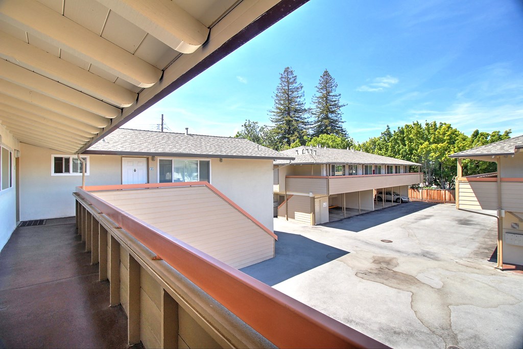 the view from the balcony of a house with a deck and a parking lot