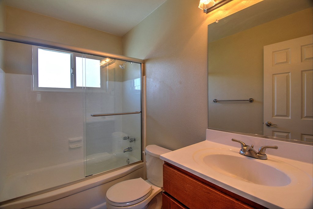 a bathroom with a shower sink and toilet and a mirror