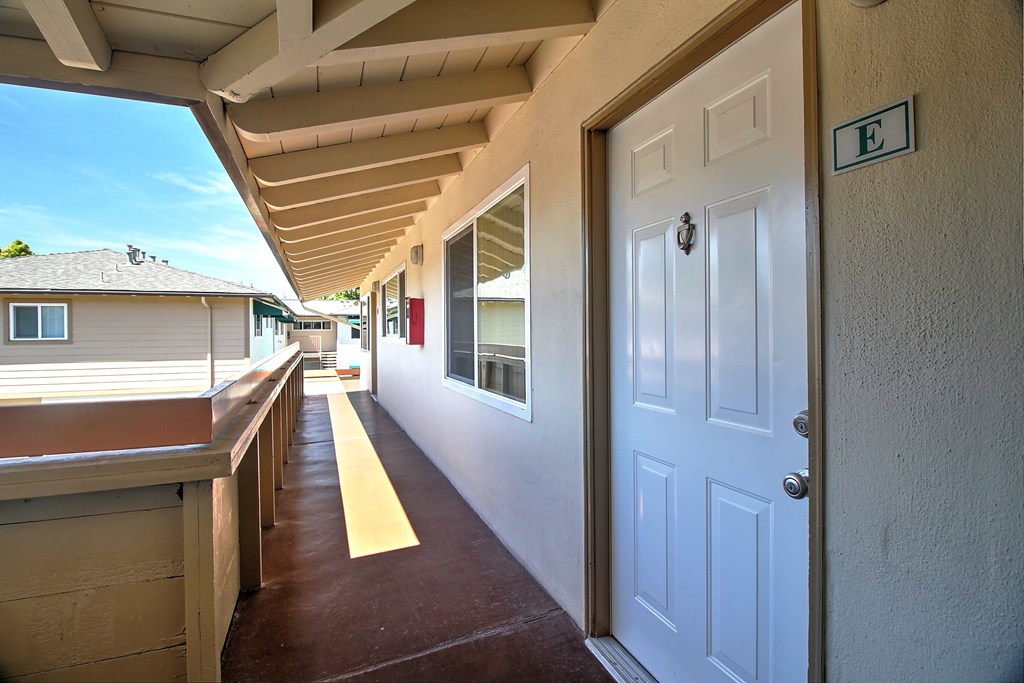 the entrance to a porch with a white door
