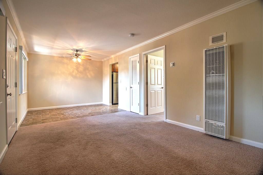 an empty living room with a ceiling fan