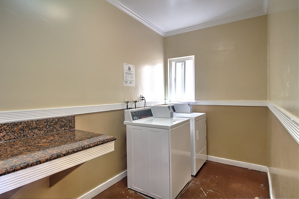 a washer and dryer in a laundry room with a bench