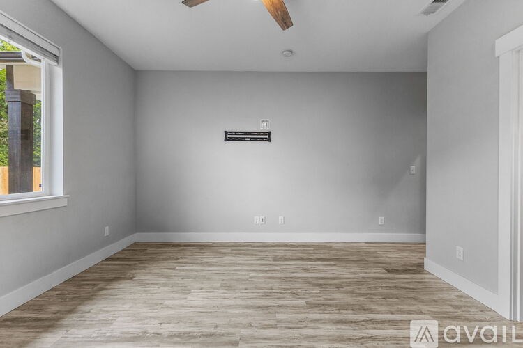 A room with wooden flooring and a ceiling fan.