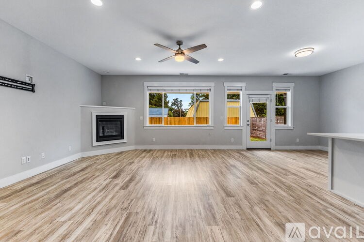 A spacious room with a ceiling fan and a fireplace.