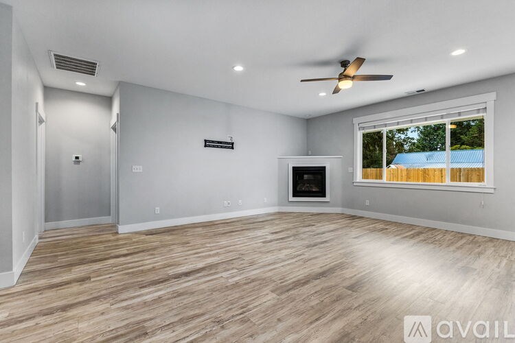 A spacious room with a ceiling fan and a television.