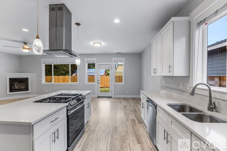 A modern kitchen with a stove top oven and a sink.