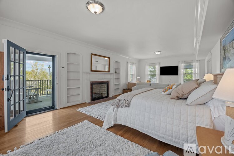 A bedroom with a large bed and a fireplace.