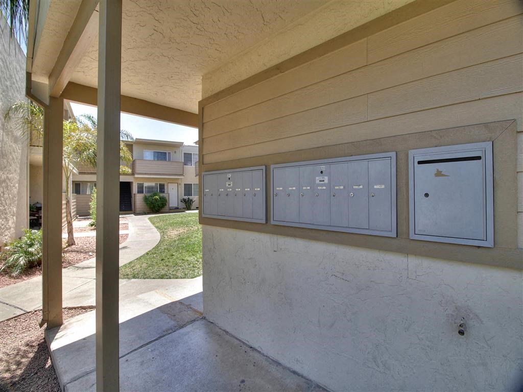 A row of mailboxes on a wall outside a building.