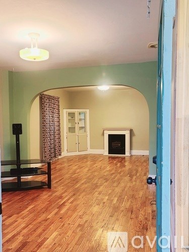A room with a fireplace and a wooden floor.