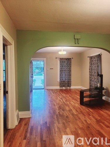 A room with wooden floors and a green wall.