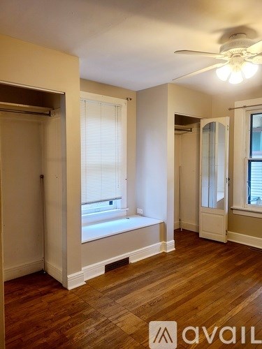 A room with a window and a fan on the ceiling.