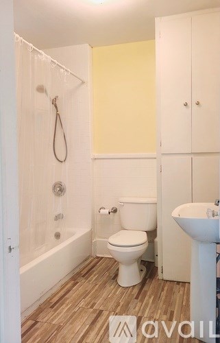 A bathroom with a toilet, sink, and shower.