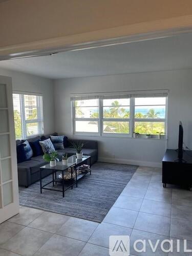 A living room with a grey sofa and a glass coffee table.