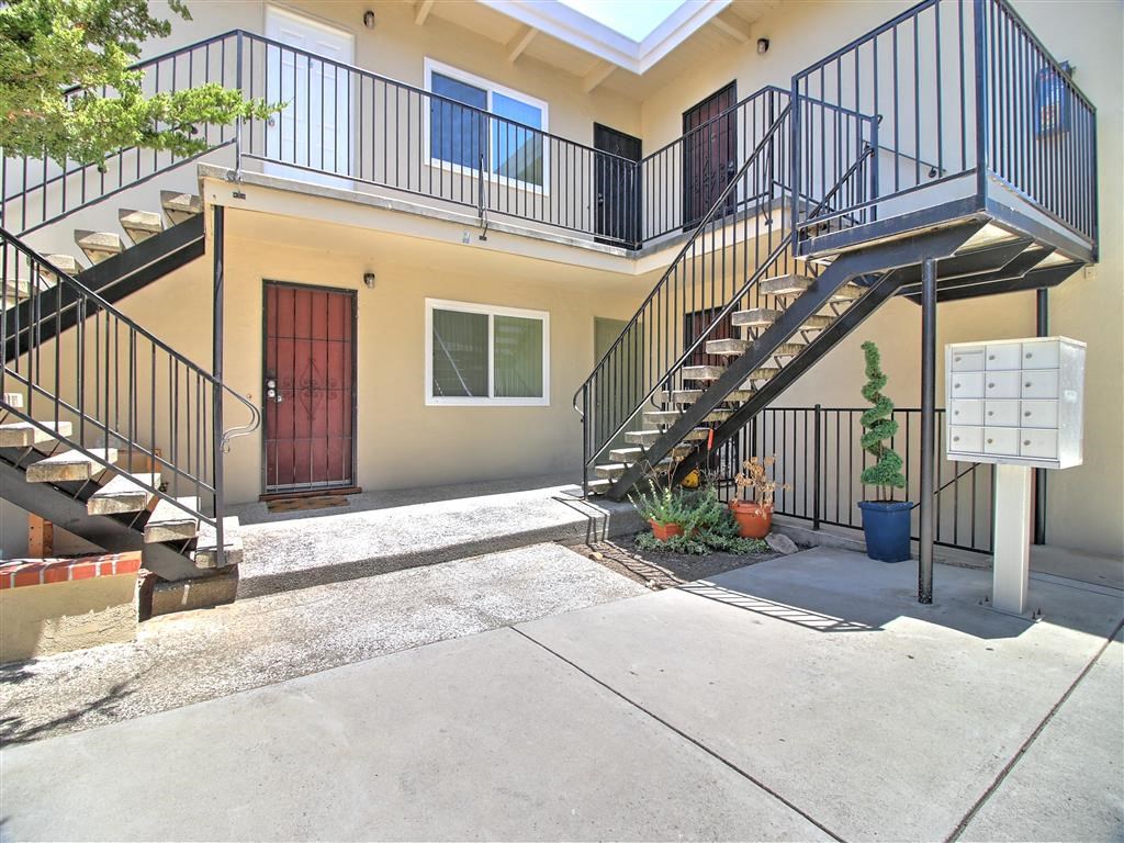 the front of a building with stairs and a driveway