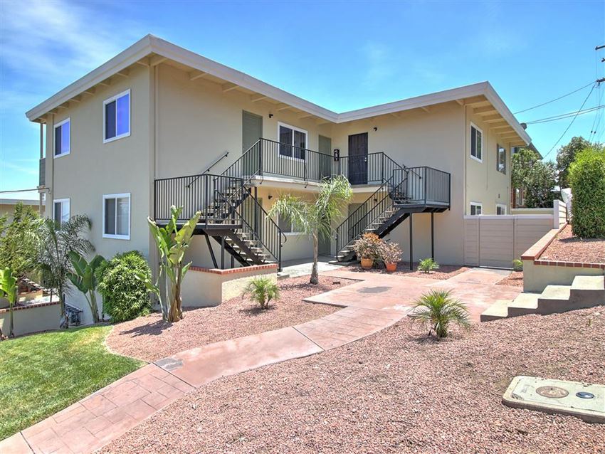 a house with a staircase and a yard in front of it