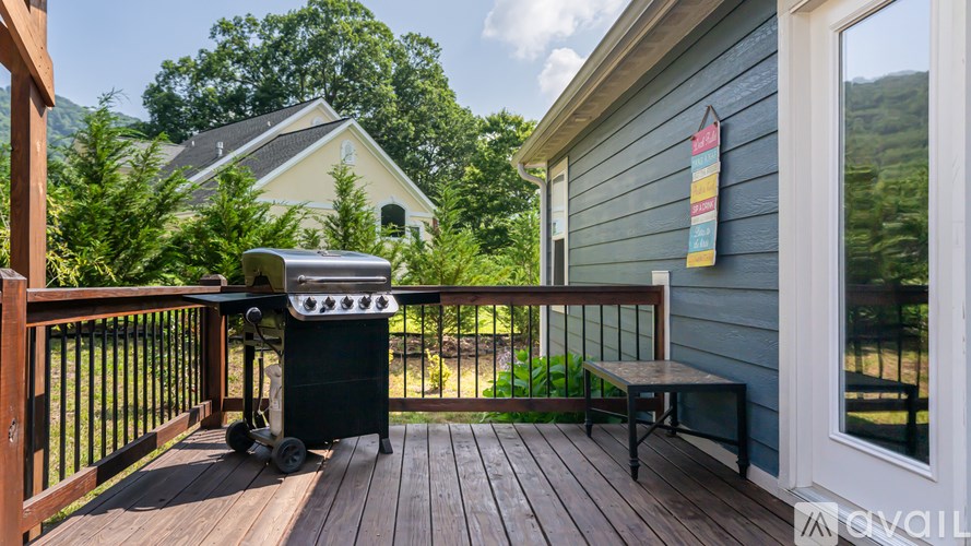 A small outdoor deck with a grill and a bench.