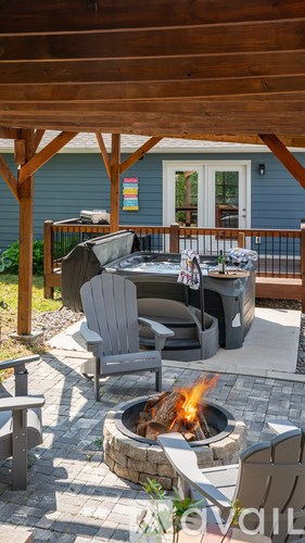 A patio with a fire pit and chairs.