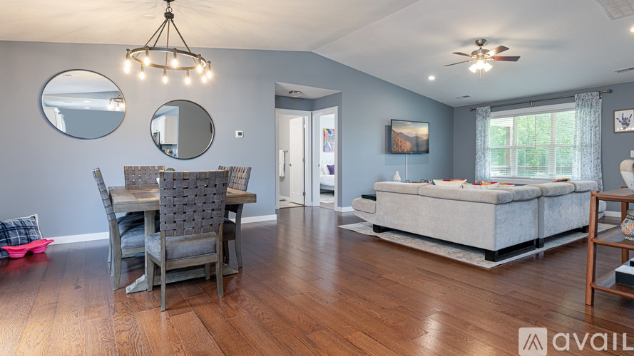 A living room with a grey couch and a wooden floor.