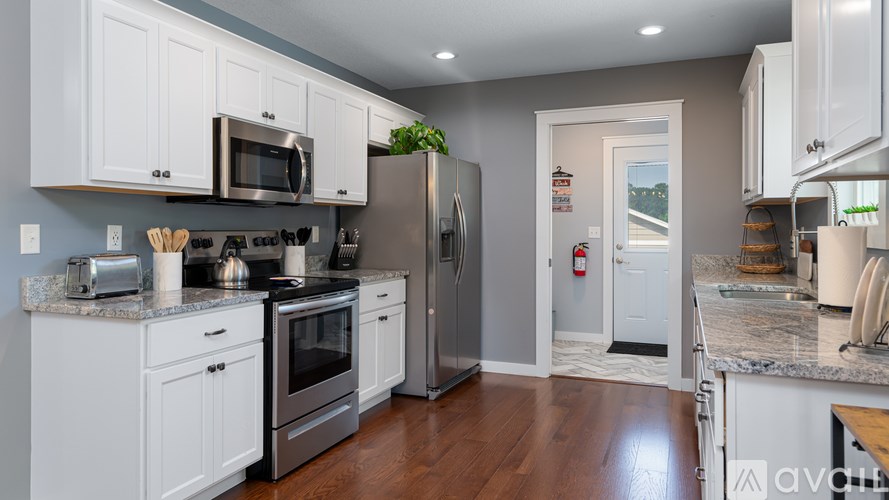 A kitchen with white cabinets and stainless steel appliances.