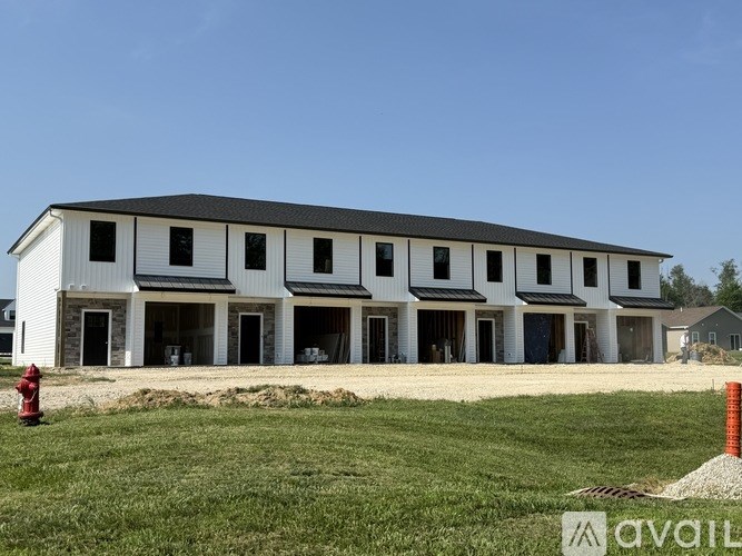 A large white building with a black roof and a red fire hydrant in front of it.