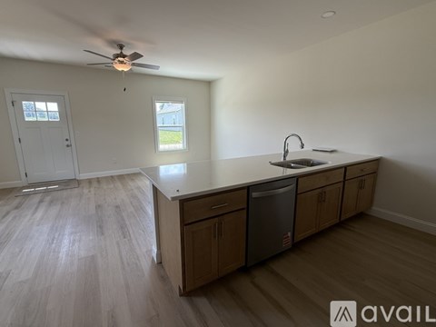 A kitchen with a fan on the ceiling and a dishwasher under the counter.