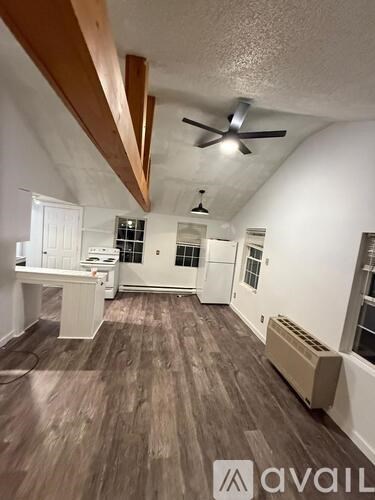 A room with wooden floors and a ceiling fan.
