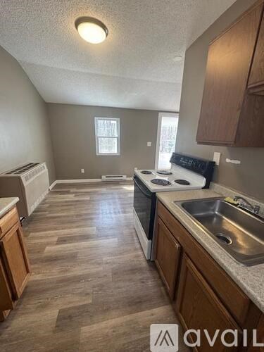 A kitchen with wooden cabinets and a stove top oven.
