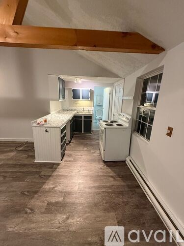 A room with wooden flooring and a white door.
