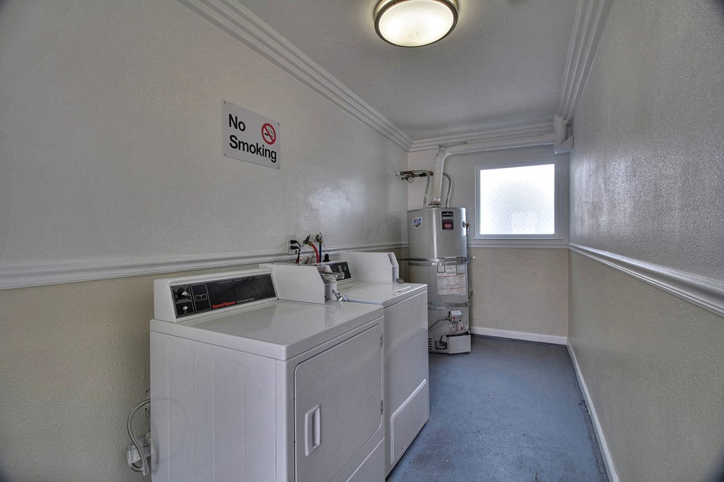 a laundry room with two machines and a window