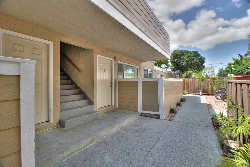 the front of a building with stairs and a sidewalk