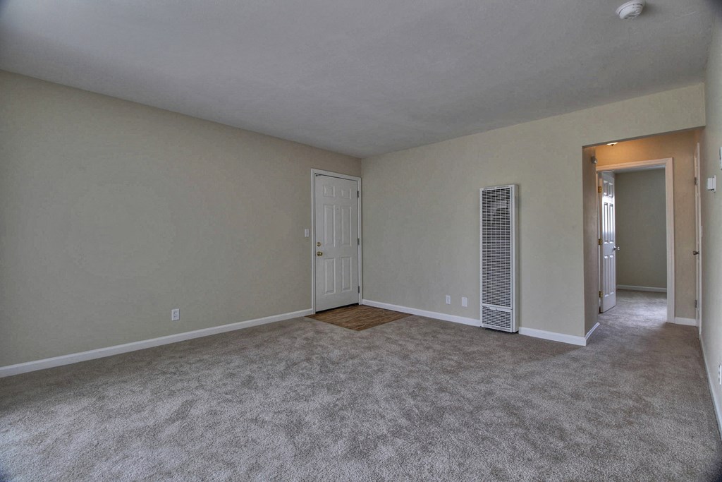 an empty living room with an open door to a closet