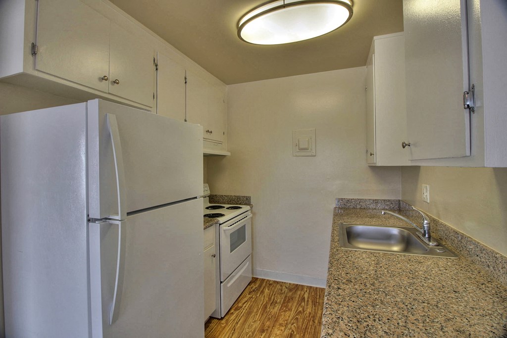 a kitchen with white appliances and a sink and a refrigerator