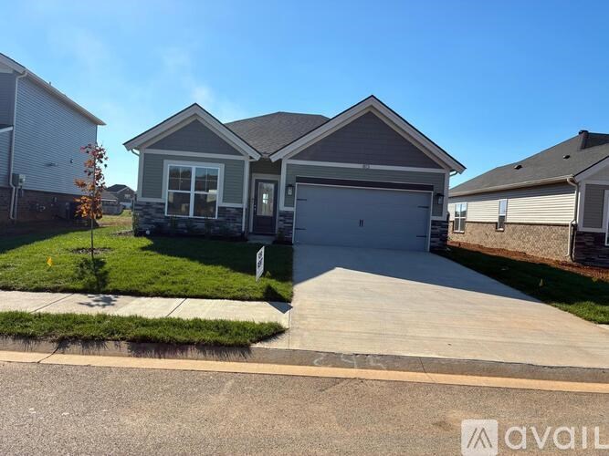 A house with a grey garage door is for sale.