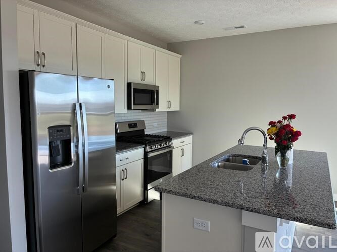 A kitchen with a granite countertop and stainless steel appliances.