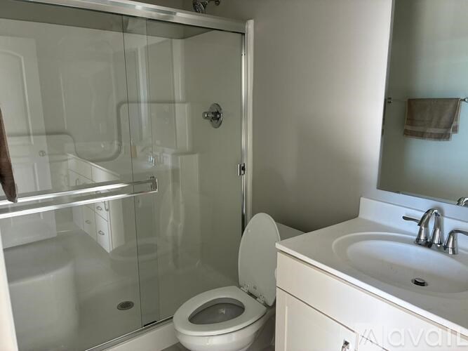 A bathroom with a toilet, sink, and shower.