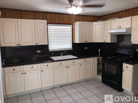 A kitchen with black countertops and white cabinets.