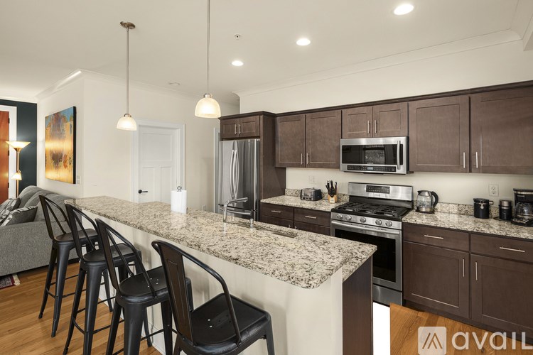 A kitchen with brown cabinets and a granite countertop.
