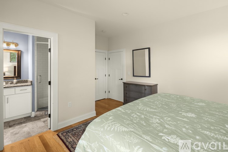 A bedroom with a bed, dresser, and mirror.
