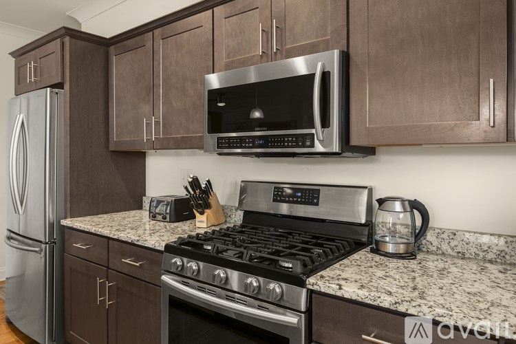 A kitchen with a stove, microwave, and refrigerator.