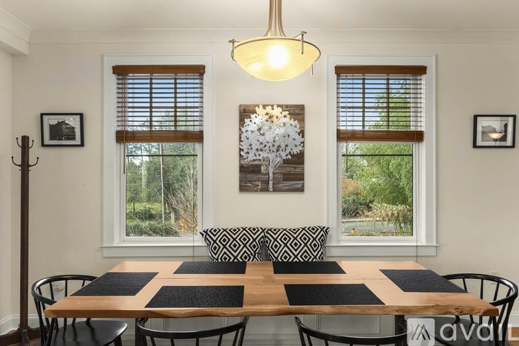 A dining room with a wooden table and chairs.