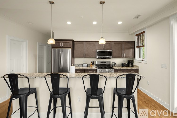 A kitchen with black chairs and a white counter.