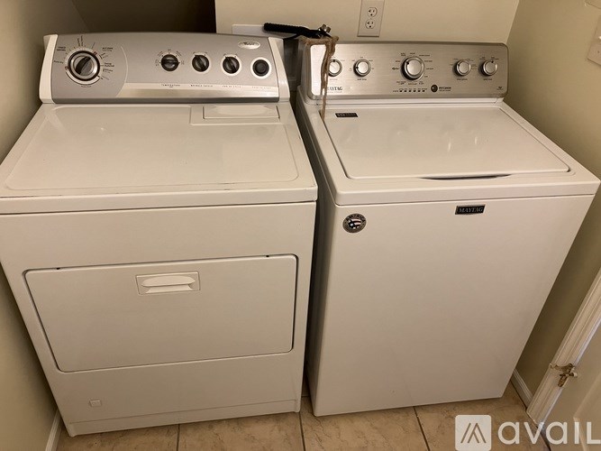 A white dryer and washer are sitting next to each other.