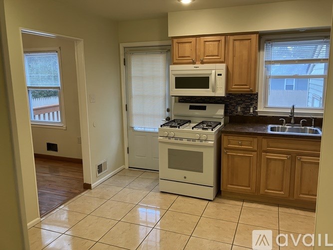 A kitchen with a white stove top oven and microwave above it.