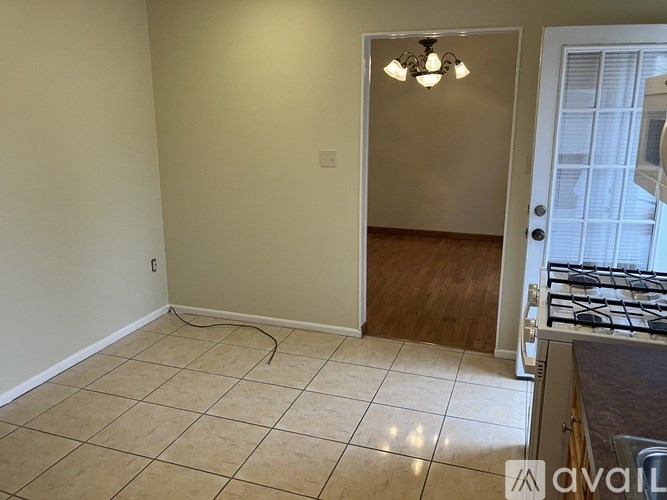 A room with a tile floor and a door leading to another room.