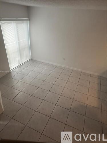 A room with tiled flooring and a window with blinds.