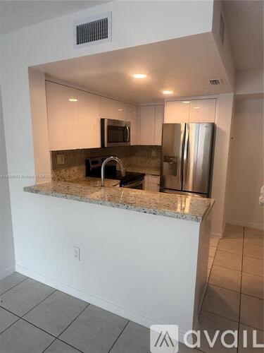 A kitchen with a granite countertop and stainless steel appliances.