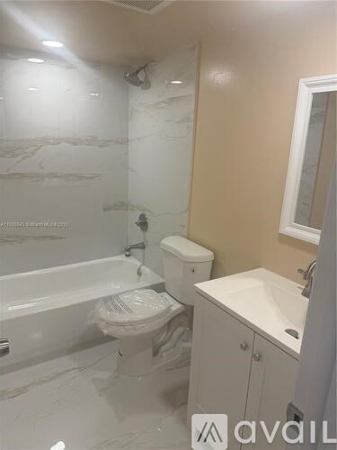 A bathroom with a tub, toilet, and sink.