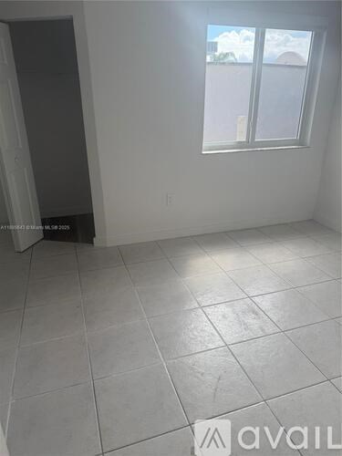 A room with a window and a tiled floor.