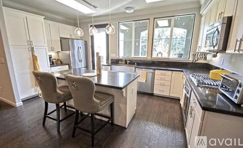 A kitchen with a table and chairs in front of a window.