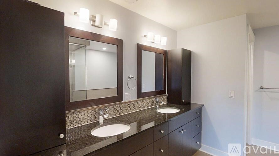 A bathroom with a sink, mirror, and cabinets.