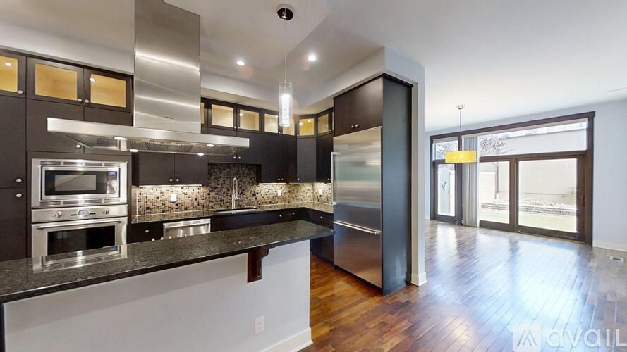 A modern kitchen with dark wood cabinets and stainless steel appliances.